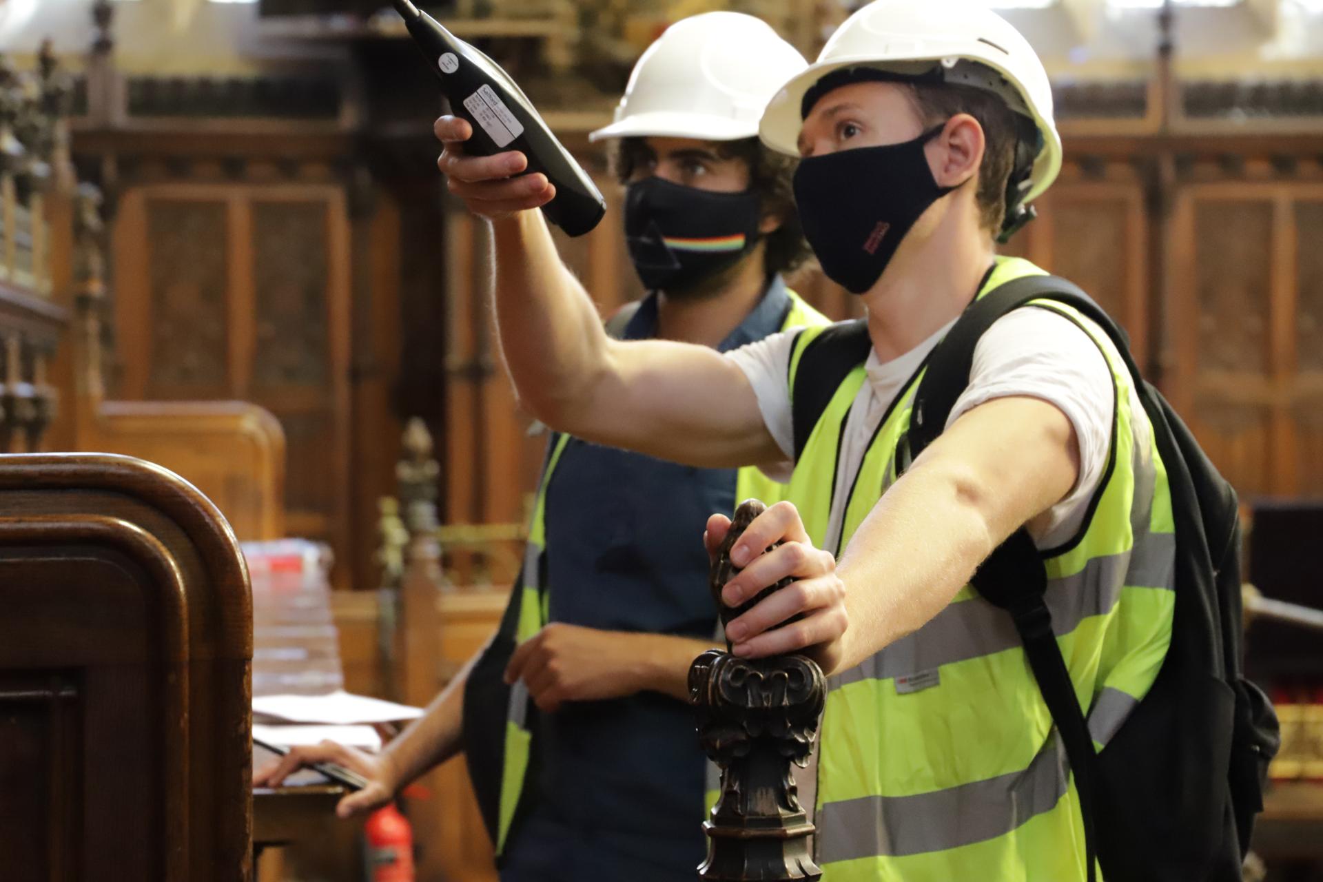 Two workers survey the House of Lords Chamber.